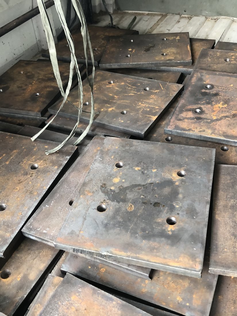 Drilled steel column base plates laid out in the fabrication yard — Southend